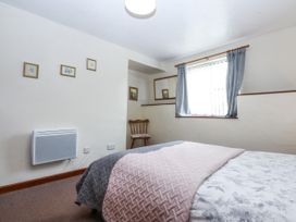 A bedroom with a bed and chair at Florence Cottage in Holyhead