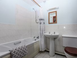 A bathroom with a bathtub, shower, wash basin, and toilet at Florence Cottage Holyhead
