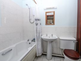 A bathroom with a bathtub, sink, and toilet at Florence Cottage in Holyhead