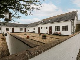 An outdoor courtyard with a bench and planters at Florence Cottage in Holyhead