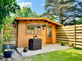 A garden shed with a table and chairs at Harvey's Lodge in Helston