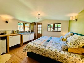 A bedroom with a kitchenette and bed at Harvey's Lodge in Helston