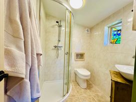A bathroom featuring a shower, toilet, and sink at Harvey's Lodge, Helston