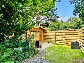 A garden with a shed and potted plants at Harvey's Lodge in Helston