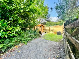 A garden with a wooden shed and pathway at Harvey's Lodge in Helston