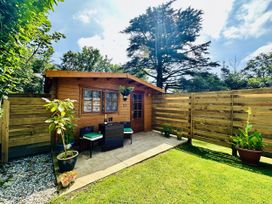A garden shed with chairs and a table at Harvey's Lodge, Lowertown, Helston