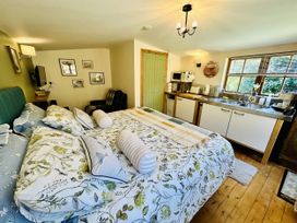 A bedroom with a kitchenette and a bed at Harvey's Lodge in Lowertown, Helston