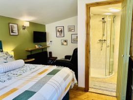 A bedroom with a shower in the corner at Harvey's Lodge in Lowertown, Helston