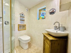 A bathroom with a shower, toilet, and sink at Harvey's Lodge in Lowertown, Helston