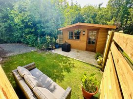 A garden with a cabin and seating area at Harvey's Lodge in Lowertown, Helston