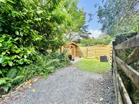 A garden with a shed and a gravel path at Harvey's Lodge in Lowertown, Helston