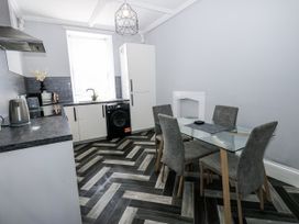 A kitchen with a dining table and appliances at Lowther House in Whitehaven