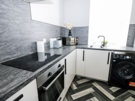 A kitchen with appliances and sink at Lowther House Whitehaven