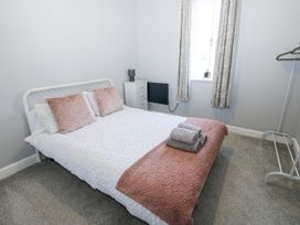 A bedroom with a bed and dresser at Lowther House in Whitehaven