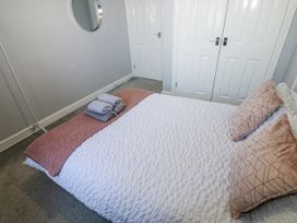A bedroom with a bed and towels folded on it at Lowther House in Whitehaven