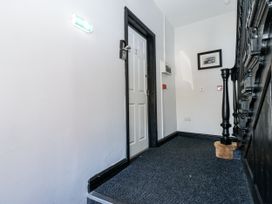 A hallway with a door and a staircase at Lowther House in Whitehaven