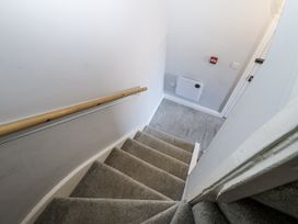 A staircase with a handrail and door at Lowther House in Whitehaven