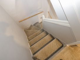 A staircase with carpet and a handrail at Lowther House in Whitehaven