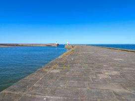 A pier with lighthouses at the end overlooking the ocean at Lowther Apartment in Whitehaven