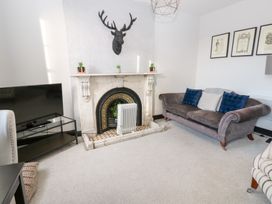 A living room with a sofa and television at Lowther Apartment in Whitehaven