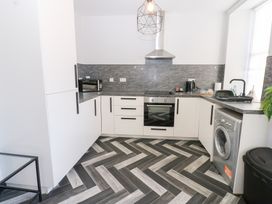 A kitchen with appliances and cabinets at Lowther Apartment in Whitehaven