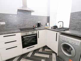 A kitchen with an oven and washing machine at Lowther Apartment in Whitehaven