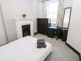 A bedroom with a bed and dresser at Lowther Apartment in Whitehaven