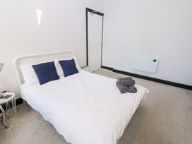 A bedroom with a bed and towels at Lowther Apartment in Whitehaven
