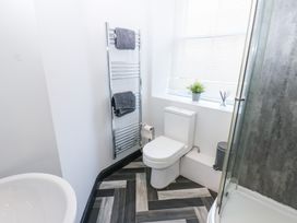 A bathroom with a toilet and shower at Lowther Apartment in Whitehaven