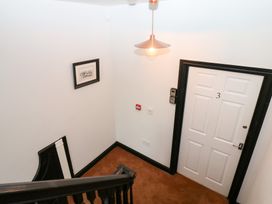 A staircase and door in a hallway at Lowther Apartment in Whitehaven