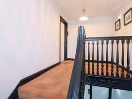 A hallway with a staircase and doors at Lowther Penthouse in Whitehaven