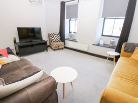 A living room with a television and seating arrangements at Lowther Penthouse in Whitehaven