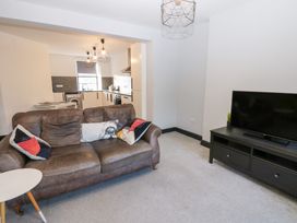 A living room with a sofa and television at Lowther Penthouse in Whitehaven