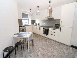 A kitchen with appliances and table at Lowther Penthouse in Whitehaven