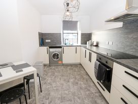 A kitchen with a washing machine and a table at Lowther Penthouse in Whitehaven