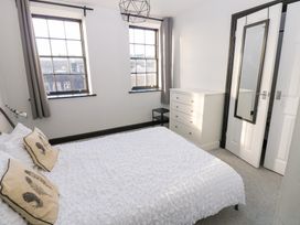 A bedroom with a bed and dresser at Lowther Penthouse in Whitehaven