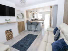 A living room with a television, sofa and kitchen island at Keekle Terrace in Cleator Moor