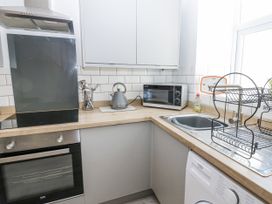 A kitchen with appliances including an oven and microwave at Keekle Terrace in Cleator Moor