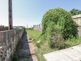 A garden area with a pathway and overgrown vegetation at Keekle Terrace Cleator Moor