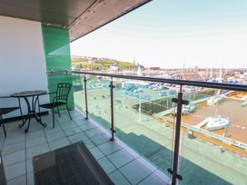A balcony with a table and chairs overlooking a marina at Pears Suite Whitehaven