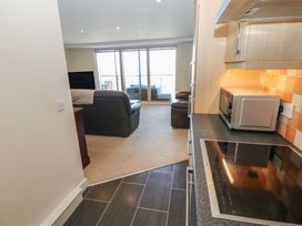 A kitchen with a stove and microwave visible at Pears Suite Whitehaven