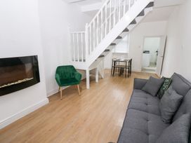 A living room with a sofa and a dining table at Holly House in Waberthwaite