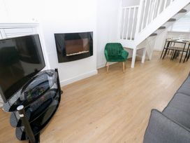A living room with a television and dining table at Holly House in Waberthwaite