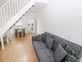 A living room with a sofa and dining table at Holly House in Waberthwaite