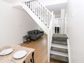 A living room with a sofa and dining area at Holly House in Waberthwaite