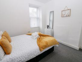 A bedroom with a bed and mirror at Holly House in Waberthwaite
