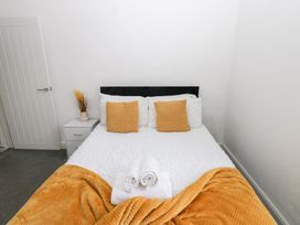 A bedroom with a bed and nightstand at Holly House in Waberthwaite