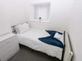 A bedroom with a bed and dresser at Holly House in Waberthwaite