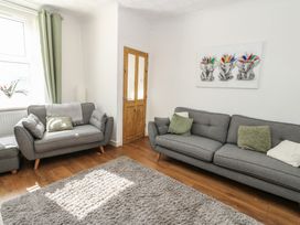 A living room with two sofas, a rug, and wall art at Lonsdale Street