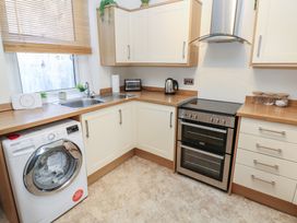 A kitchen with a washing machine, sink, kettle, and oven at Lonsdale Street